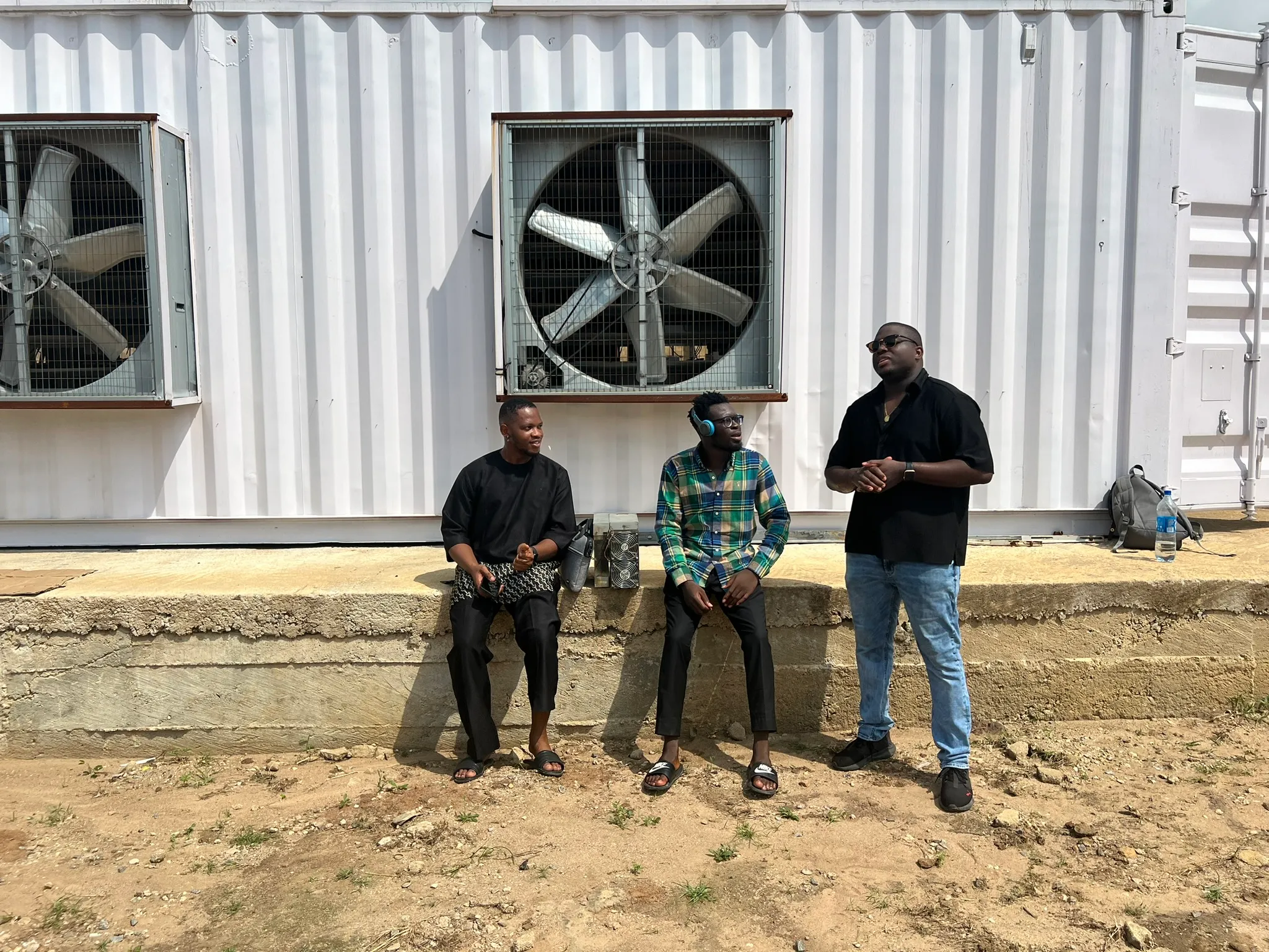 NRG Bloom CEO and Shugamine discussing in front of a Bitcoin mining container iin Nigeria